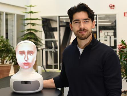 Alexander Borg, doctoral student at the Department of Medicine, Solna, next to the AI-driven robot patient used in teaching at KI.