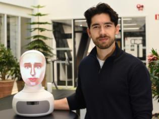 Alexander Borg, doctoral student at the Department of Medicine, Solna, next to the AI-driven robot patient used in teaching at KI.